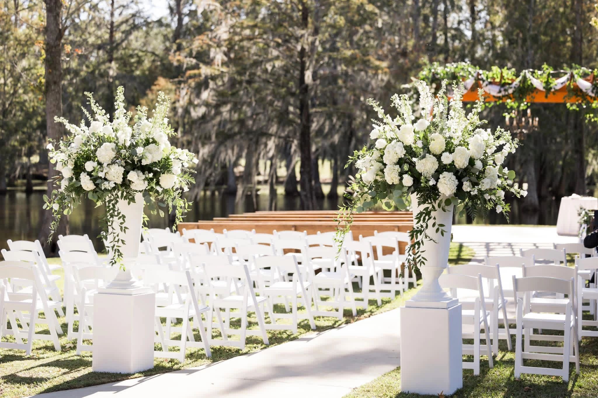 Outdoor wedding setup with white flowers and chairs.