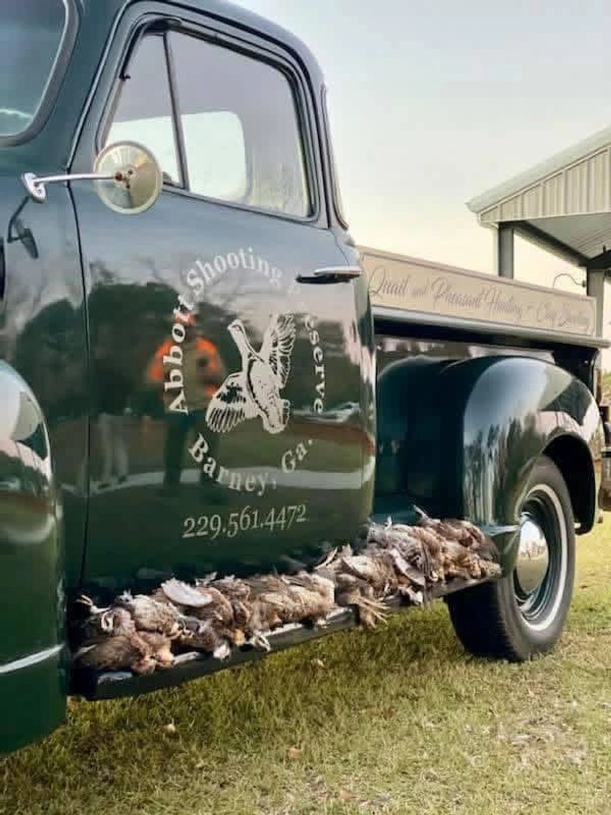 Vintage hunting truck with game birds displayed on the running board.