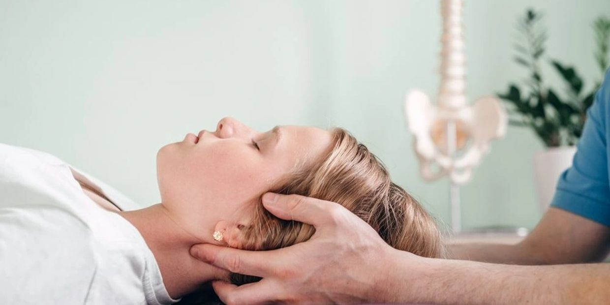 Woman receiving neck therapy from a professional in a clinical setting.