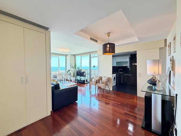 Modern living room with wooden floors and ocean view.