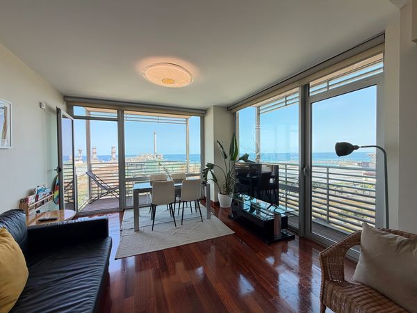 Modern living room with ocean view and large windows.
