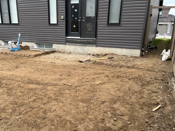 Backyard construction site with dirt and tools.