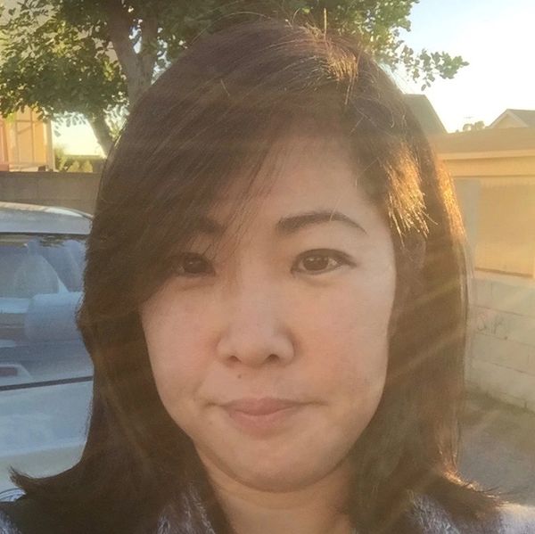 Woman taking a selfie outdoors in sunlight.