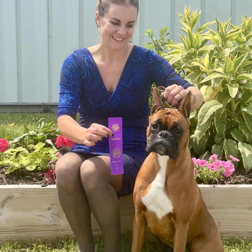 Woman with her winning dog and ribbon.
