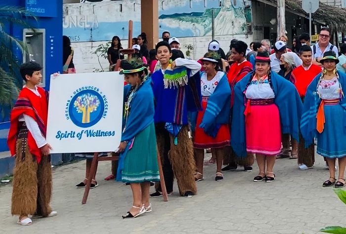 Spirit of Wellness office sign being held by comuna members.

