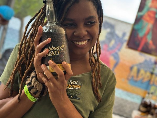 a pretty girl smiling holding a bottle of whiskey