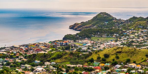 Coastal town with houses, hills, and ocean view.