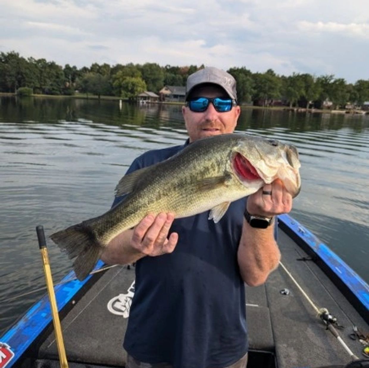 Man holding a large fish on a boat.