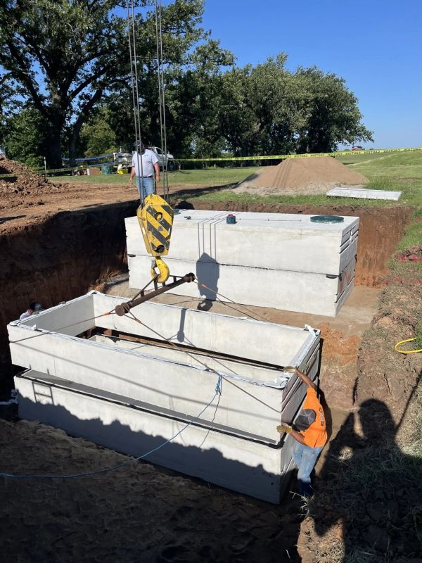 Workers installing large concrete structures with crane.
