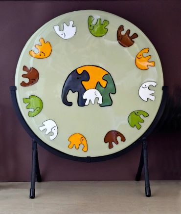 Colorful elephant-themed circular artwork on a stand.