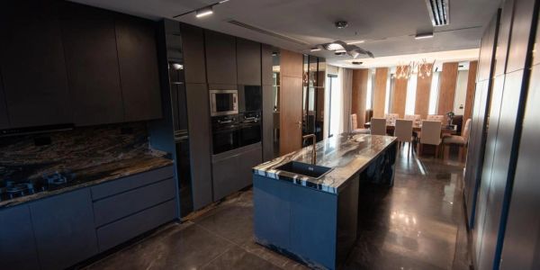 Modern kitchen with dark cabinets and stone island.