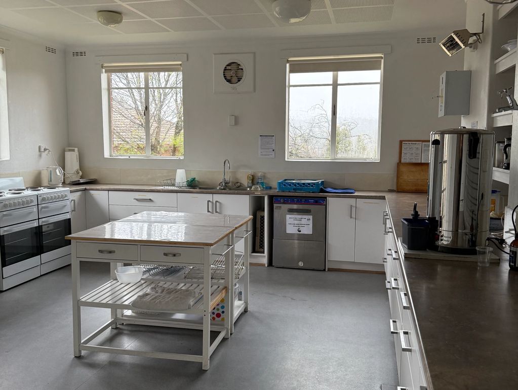 A clean, bright kitchen with two windows and central island.