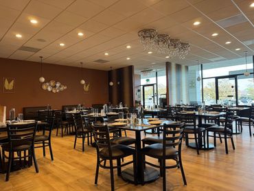Empty modern restaurant with neatly arranged tables and chairs.