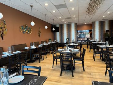 Elegant and cozy restaurant interior with neatly set tables and warm lighting.