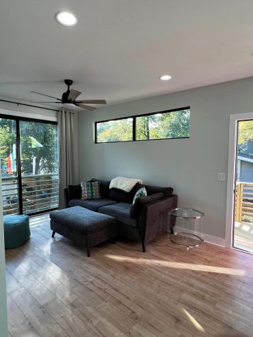 Modern living room with gray sectional sofa and large windows.
