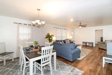 Spacious living and dining area with modern furniture and wooden floors.