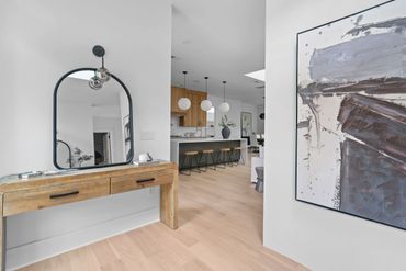 Minimalist entryway with a wooden console table and arched mirror.