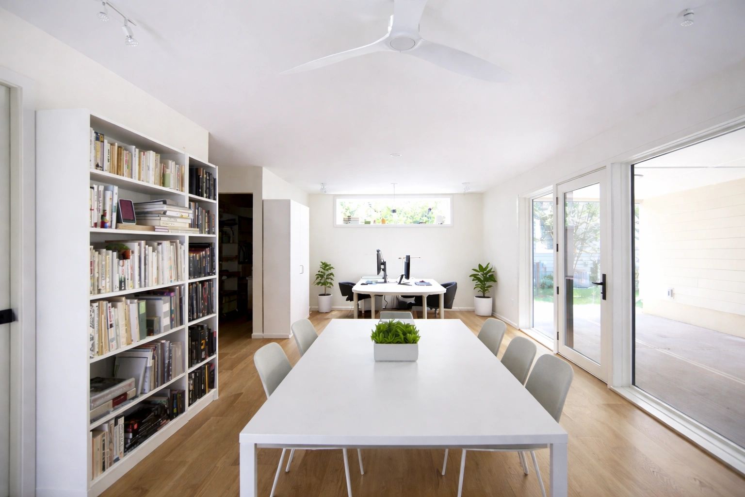 Bright modern office space with white furniture and wooden floors.
