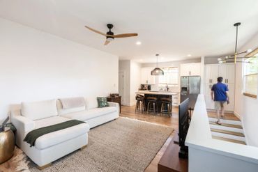 Bright open living room and kitchen with modern decor and natural light.
