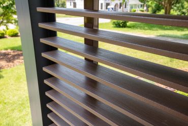 Close-up of horizontal wooden slats with a garden view.