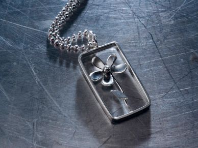 Silver flower pendant on a chain.