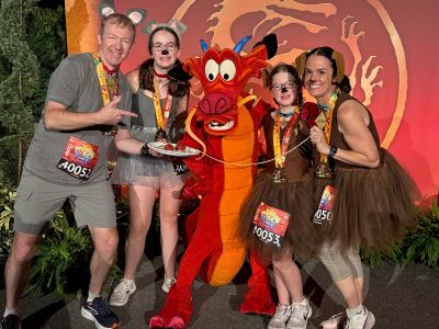 Group in costumes posing with Mushu the dragon.