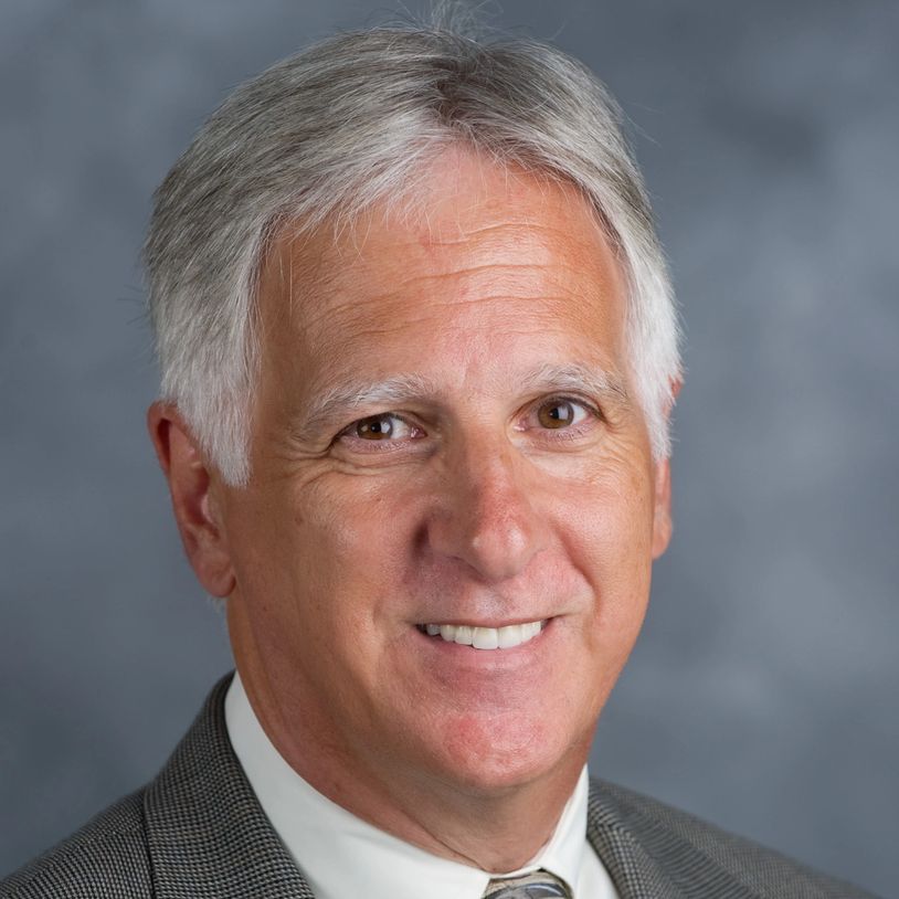 Smiling older man in a suit.