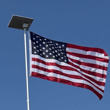 American flag flying against a clear blue sky.