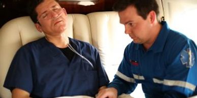 Medical professional receiving care from a paramedic inside a vehicle.