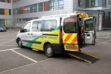 A patient transport ambulance with an open rear door and a ramp extended.