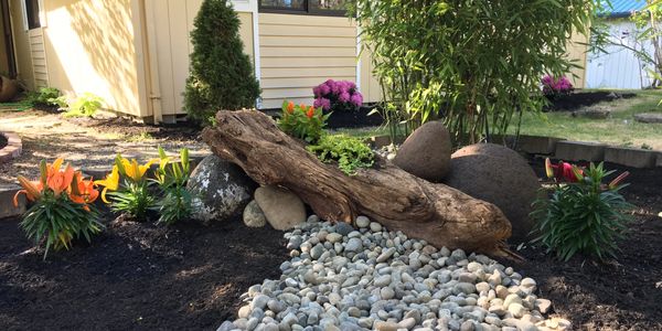 CKLD Zen garden with natural wood, river rock, colorful plantings and a dry creek bed.