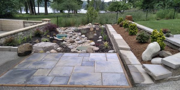 Custom slate patio, stonework and landscaped garden overlooking the water in Olympia, WA.
