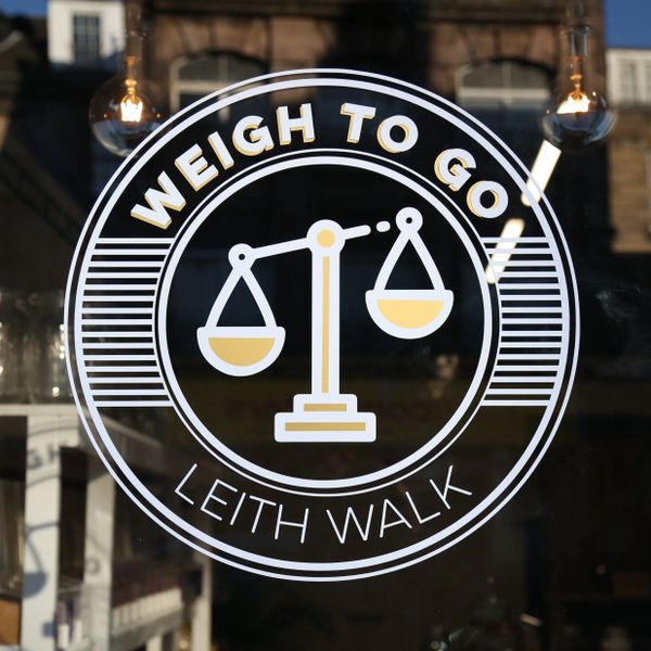 Edinburgh sustainable shop "Weigh To Go" logo on Leith Walk's shop front window.