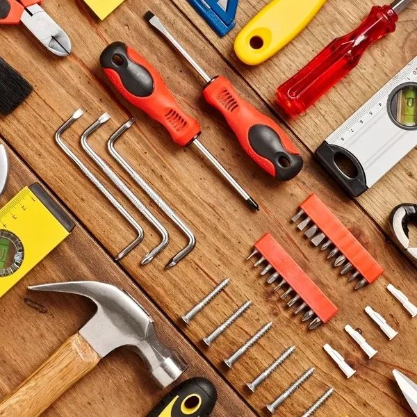 Various hand tools arranged on a wooden surface.