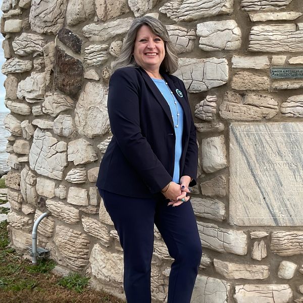 Attorney Kristina M. Sanders-Brown standing beside a stone wall.