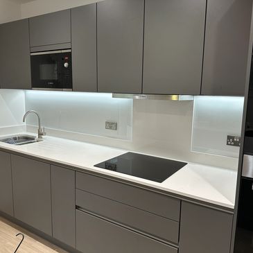 Modern kitchen with gray cabinets and white countertop.