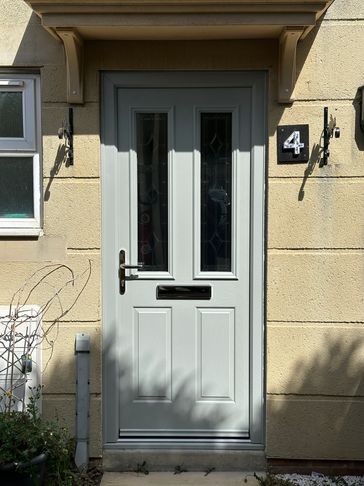 White front door with glass panels and number 4 plaque.