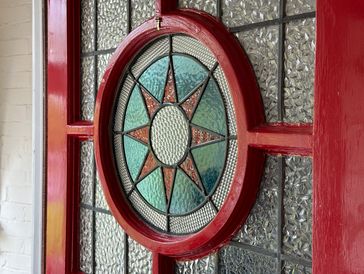 Decorative stained glass window with a red frame.