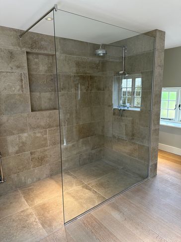 Modern walk-in shower with glass enclosure.