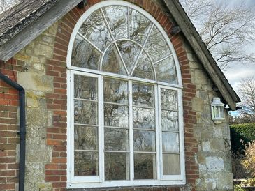 Large arched window on a rustic stone building.