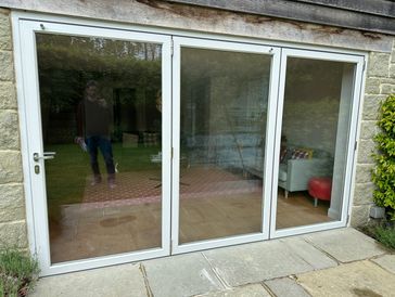 Glass sliding door with reflection and partial view inside.