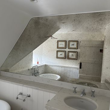 Vintage-style bathroom with clawfoot tub and large mirror.