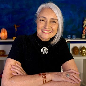 Mulher sorridente de cabelo branco com blusa preta.