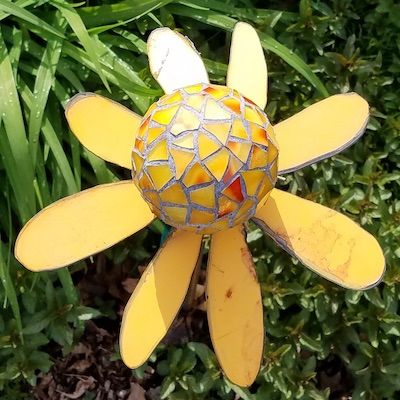 Metal flower plasma cut from a car hood, mosaic center.
