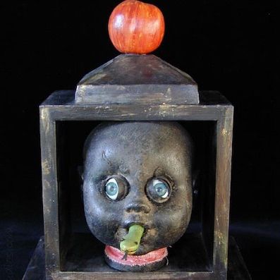 Temptation. Mixed media doll art. Plastic doll parts, wood frame, paper clay, fabric, carved snake.