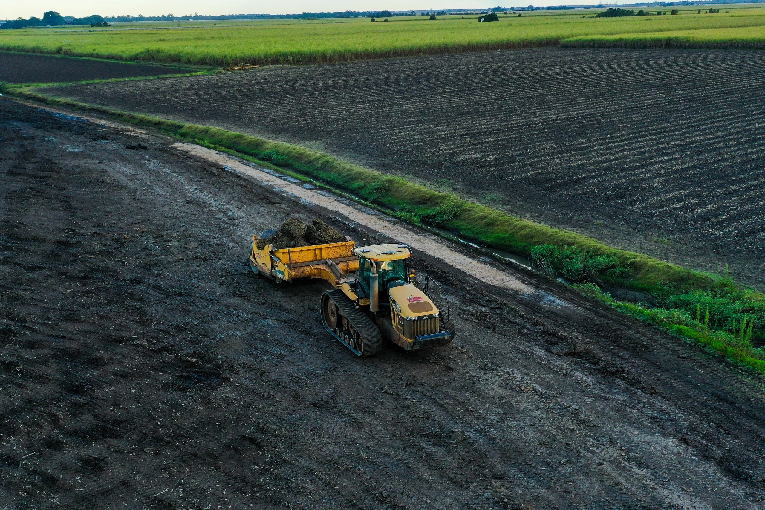 Tractor scraper cutting an irrigation bay — aerial view