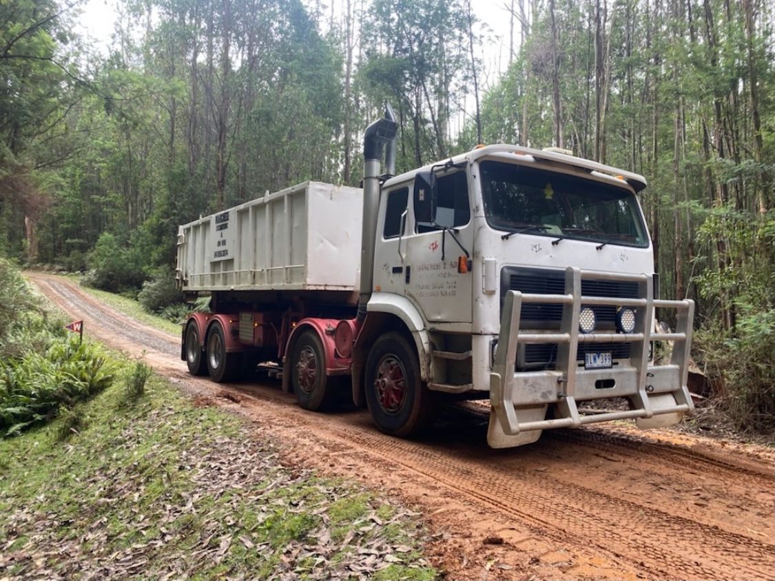 Hook-lift truck delivering a skip bin