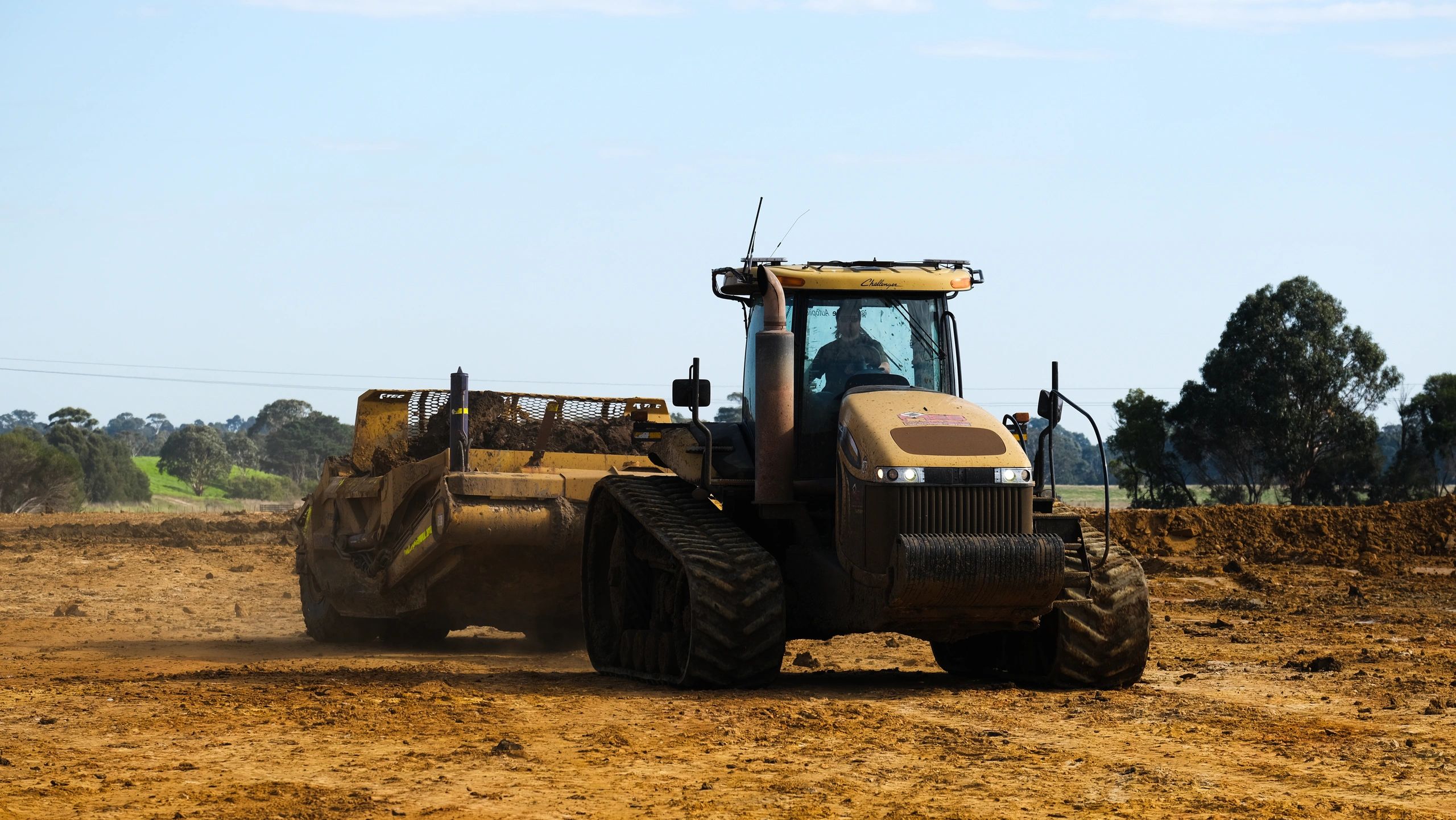 Tracked tractor with scraper