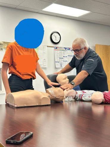 Instructor teaching CPR on mannequins.