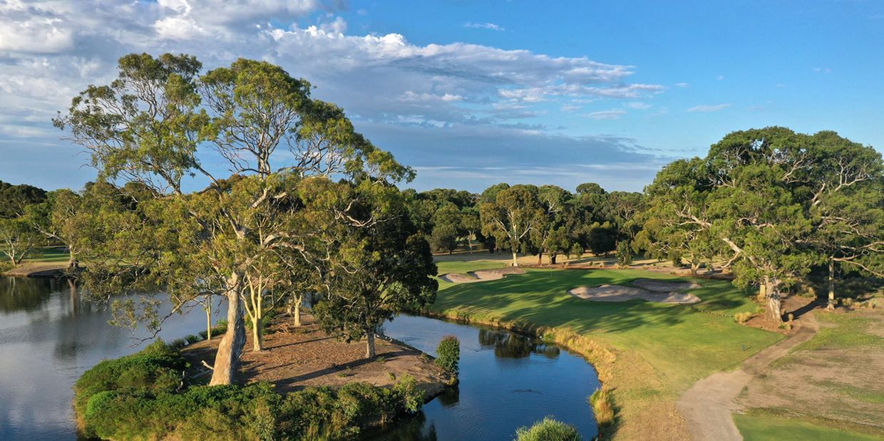 Scenic golf course with water and trees.